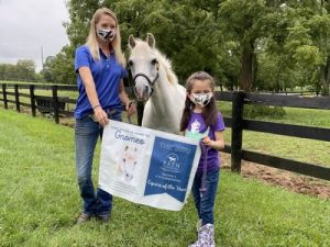 Mini Horse Gnomeo with little girl and woman holding banner